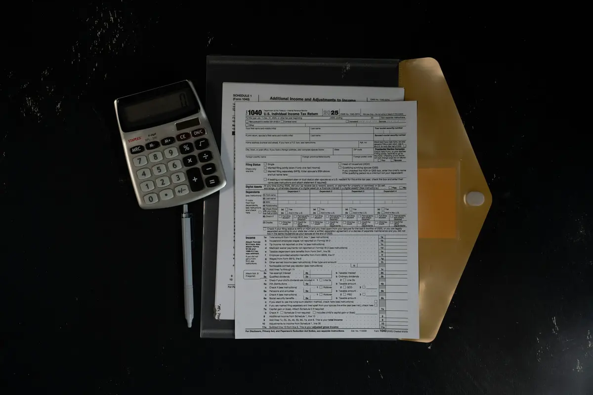 Calculator and financial paperwork arranged in a folder